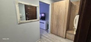 a bathroom with a urinal and a mirror on a wall at Apartament SORENTO 7 in Gorzów Wielkopolski