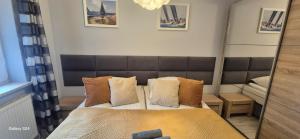 a small bedroom with a bed and a mirror at Apartament SORENTO 7 in Gorzów Wielkopolski