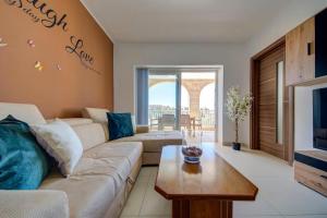 a living room with a couch and a table at Gozo Getaway! Heated Jacuzzi & Views in Xagħra