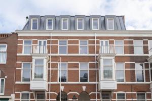 a red brick building with a gray roof at Hotel Zest Den Haag - Scheveningen in Scheveningen