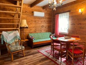 a living room with a couch and a table and chairs at Brzozowy Zakątek in Waśki