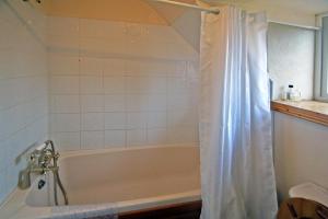 a bath tub with a shower curtain in a bathroom at 3 Bed in Cahirciveen oc-i417 in Reenard Cross