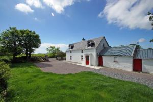a white house with red doors and a driveway at 3 Bed in Cahirciveen oc-i417 in Reenard Cross