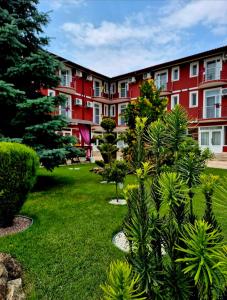 a large red building with plants in a yard at Vila Diamond in Saturn