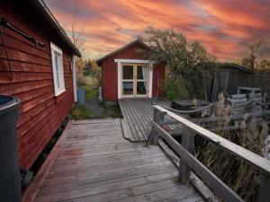 a wooden walkway leading to a red house at Fisherman's cottage in Björköby