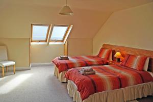 a bedroom with two beds and a chair and two windows at 4 Bed in Inch oc-i183 in Anascaul