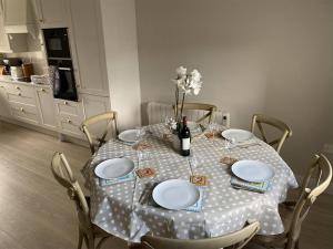 a dining room table with plates and a bottle of wine at 3 Bed in Doonbeg oc-ii15918 in Kilrush