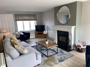 a living room with a white couch and a mirror at 3 Bed in Doonbeg oc-ii15918 in Kilrush