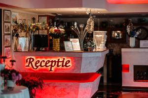a bar with a red neon sign that says recycle at Vila Diamond in Saturn