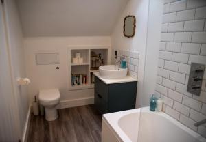 a bathroom with a sink and a toilet and a tub at The End in Langport +24 photos