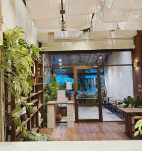 an open lobby with plants and a table at Nuan Nil Secret Courtyard in Chiang Mai