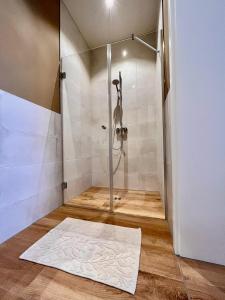 a shower with a glass door and a white rug at Ferienwohnung in Cammer