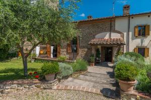 a stone house with a pathway leading to the front door at Antica Filanda Sunshine in Arezzo