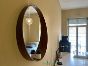 a mirror on a wall with two potted plants at Studio élégant et lumineux pour 2 personnes in Besançon +4 photos