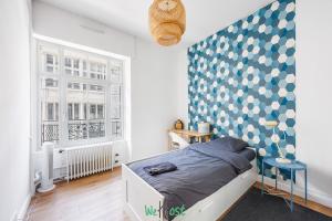 a bedroom with a bed and a blue and white wall at Grand T5 lumineux au cœur de Besançon in Besançon