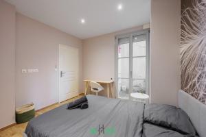 a bedroom with a bed and a window at Grand T5 lumineux au cœur de Besançon in Besançon