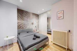 a small bedroom with a bed and a radiator at Grand T5 lumineux au cœur de Besançon in Besançon