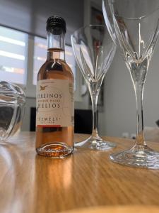 a bottle of wine sitting on a table with glasses at Ήρεμο σπίτι casa puente in Stenón