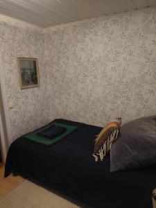 a bedroom with a bed and a wall with wallpaper at Guest room in Uppsala