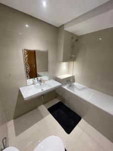 a bathroom with a sink and a tub and a toilet at Airport Luxury Residence Taj collection 1 in Casablanca +10 photos
