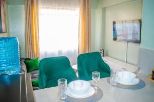 a dining room with a table and green chairs at Norlan Homes Kisumu in Kisumu