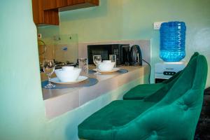a kitchen with a counter with a green couch at Norlan Homes Kisumu in Kisumu