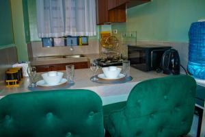 a kitchen with a table with two plates and glasses at Norlan Homes Kisumu in Kisumu