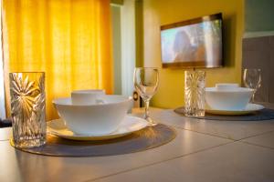 a table with two glasses and plates and bowls on it at Norlan Homes Kisumu in Kisumu +13 photos