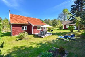 a red house with a deck and chairs in the yard at "Lönnebo" in Lönneberga