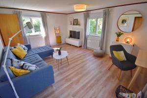 a living room with a blue couch and two chairs at "Lönnebo" in Lönneberga