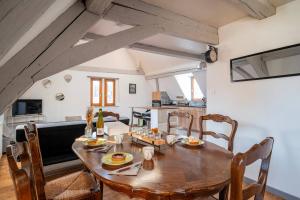 a kitchen and dining room with a wooden table and chairs at Le Nid Alsacien - Centre Ville - Proche Parking Gratuit - Europa-park in Erstein