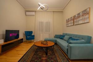 a living room with a blue couch and a table at Meteora Rockside Lodge in Kalabaka