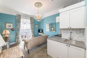 a kitchen and living room with a couch and a table at Mariners Balcony Apartment in Sidmouth