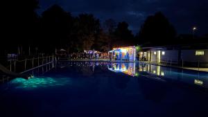 a swimming pool at night with people standing around at Wohlfühlwohnung Dauborn in Hünfelden