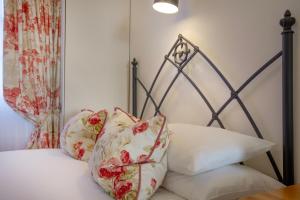 a bed with white pillows and a black frame at Mariners Balcony Apartment in Sidmouth