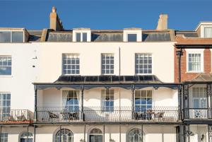 a row of white buildings with balconies at Mariners Balcony Apartment in Sidmouth