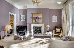 a living room with purple walls and a fireplace at Wyndham Balcony Apartment in Sidmouth