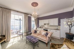 a living room with a couch and a table at Wyndham Balcony Apartment in Sidmouth