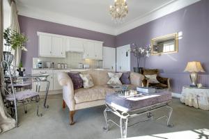 a living room with a couch and a table at Wyndham Balcony Apartment in Sidmouth +12 photos