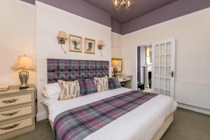 a bedroom with a large bed with a plaid headboard at Wyndham Balcony Apartment in Sidmouth