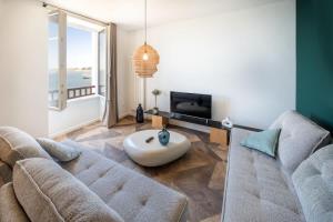 a living room with a couch and a tv at ILE STAGADON - Appartement de luxe magnifique vue mer in Landéda