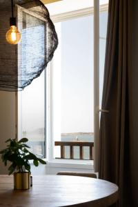 a window with a table and a plant in front of it at ILE STAGADON - Appartement de luxe magnifique vue mer in Landéda