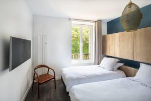 a bedroom with two beds and a chair and a window at ILE STAGADON - Appartement de luxe magnifique vue mer in Landéda +49 photos