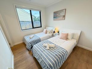 a bedroom with two beds and a couch in it at Monash Ensuite room with shared kitchen & laundry in Oakleigh East
