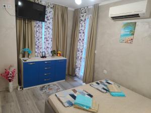 a bedroom with a blue dresser and a blue cabinet at Лукс Апартамент Морска Перла in Primorsko