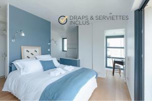 a blue and white bedroom with a bed and a desk at TY KOREJOU - splendide maison avec sauna les pieds dans l'eau in Plouguerneau