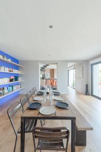 a dining room with a long table and chairs at TY KOREJOU - splendide maison avec sauna les pieds dans l'eau in Plouguerneau +44 photos