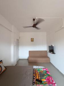a living room with a couch and a ceiling fan at Dapolihideaway in Dapoli