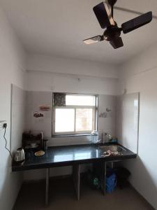 a kitchen with a table and a ceiling fan at Dapolihideaway in Dapoli