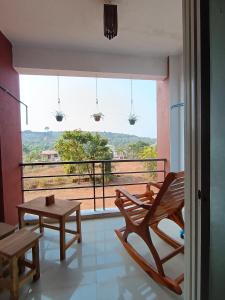 a room with a balcony with a bench and a table at Dapolihideaway in Dapoli